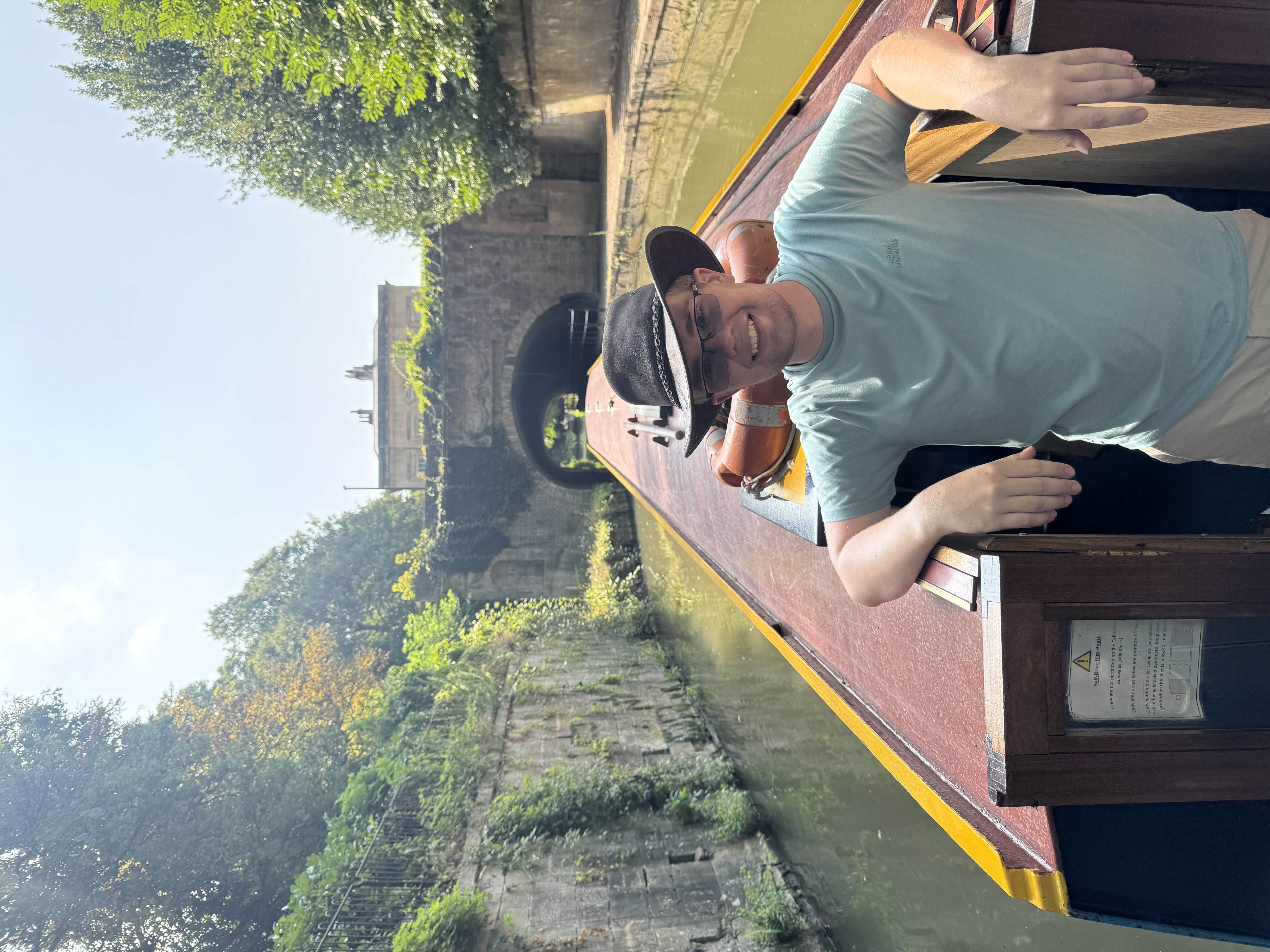 A photo of Jack Barnard, standing on a narrow boat and smilling.